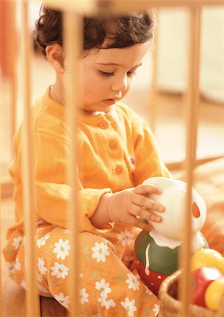 Young child looking at stuffed toy, warm toned. Stock Photo - Premium Royalty-Free, Code: 695-03381001