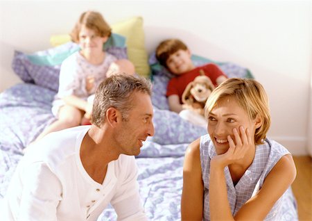 simsearch:695-03385318,k - Parents in front of children in bed. Foto de stock - Royalty Free Premium, Número: 695-03381010