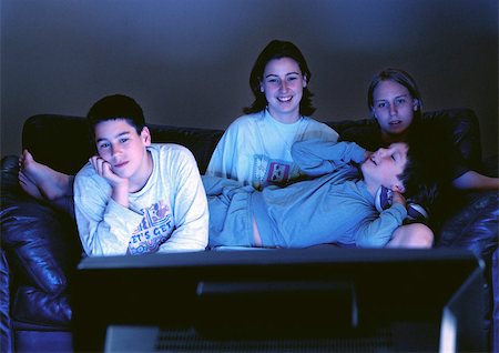 simsearch:400-04918544,k - Young adults sitting together on couch watching television in the dark. Stock Photo - Premium Royalty-Free, Code: 695-03381031