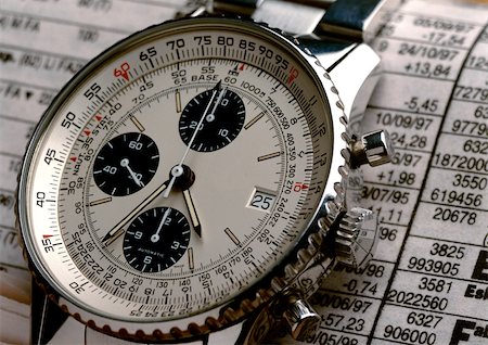 Wristwatch on top of stock report, extreme close-up Foto de stock - Sin royalties Premium, Código: 695-03381057