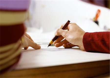 pen two hands - Hand holding pen, close-up Stock Photo - Premium Royalty-Free, Code: 695-03381198