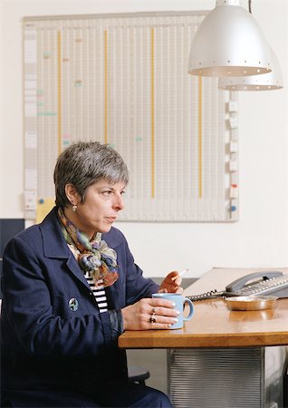 smoking cigarette office not bar - Woman sitting at table, holding cup and smoking cigarette Stock Photo - Premium Royalty-Free, Code: 695-03381233