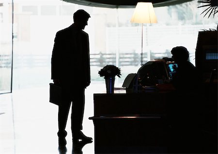 Silhouette of businessman standing by desk Stock Photo - Premium Royalty-Free, Code: 695-03381599