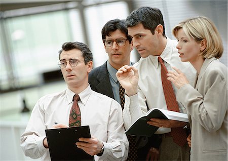 Four investors standing side by side, talking Stock Photo - Premium Royalty-Free, Code: 695-03381590