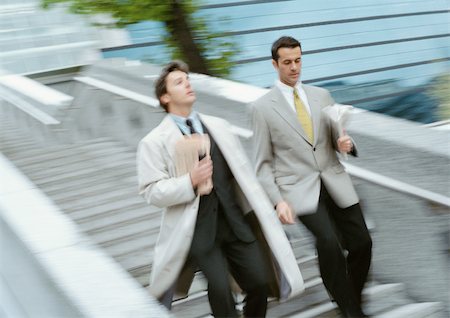 simsearch:695-03382908,k - Two businessmen going down stairs side by side, blurred Fotografie stock - Premium Royalty-Free, Codice: 695-03381605