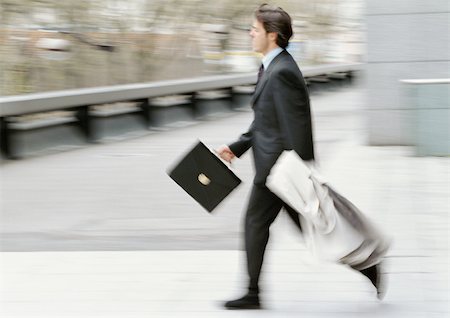 simsearch:695-03382908,k - Businessman holding briefcase and overcoat, running, blurred Fotografie stock - Premium Royalty-Free, Codice: 695-03381607