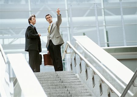 etiquette men - Two businessmen standing at the top of stairs Foto de stock - Sin royalties Premium, Código: 695-03381619