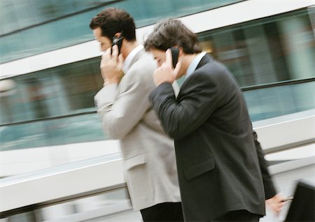Two businessmen using cell phones outside, side view Stock Photo - Premium Royalty-Free, Code: 695-03381612