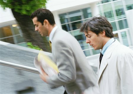 person walking up stairs - Two businessmen walking up stairs, upper section,  blurred Stock Photo - Premium Royalty-Free, Code: 695-03381662