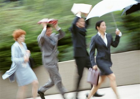 Group of business people running in rain, blurred Foto de stock - Sin royalties Premium, Código: 695-03381732