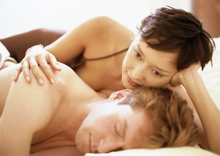 simsearch:695-05778308,k - Couple couché dans son lit, de la femme à la main sur l'épaule de l'homme Photographie de stock - Premium Libres de Droits, Code: 695-03381796