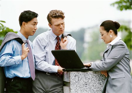simsearch:696-03398874,k - Business associates together looking at laptop computer Stock Photo - Premium Royalty-Free, Code: 695-03381955