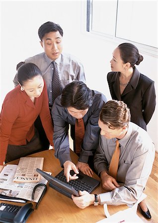 Five business associates gathered around laptop computer on table, high angle view Stock Photo - Premium Royalty-Free, Code: 695-03381976