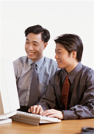 simsearch:695-05763908,k - Two businessmen looking at computer, smiling Fotografie stock - Premium Royalty-Free, Codice: 695-03381985