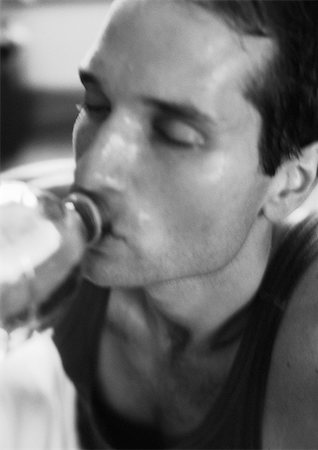 fitness black and white - Man drinking from bottle, close-up, b&w Foto de stock - Sin royalties Premium, Código: 695-03382039