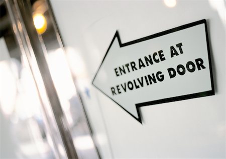 simsearch:696-03398767,k - Entrance at revolving door text on arrow sign, close-up Foto de stock - Sin royalties Premium, Código: 695-03382381