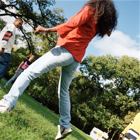 simsearch:695-03382465,k - Young people together outside, young woman jumping in foreground, rear view Stock Photo - Premium Royalty-Free, Code: 695-03382480