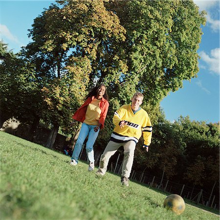 friends playing football - Young man and woman playing soccer outside. Stock Photo - Premium Royalty-Free, Code: 695-03382481