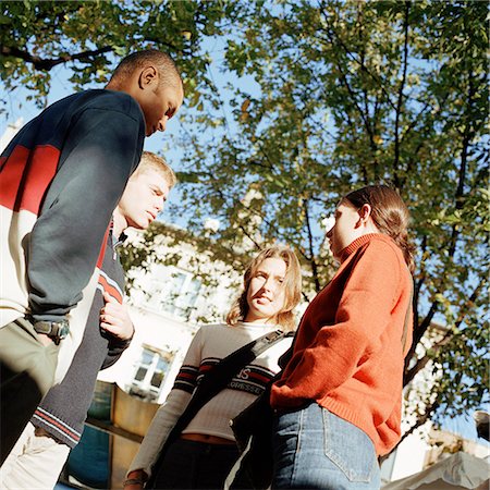 Young people talking together outside, low angle view Stock Photo - Premium Royalty-Free, Code: 695-03382508