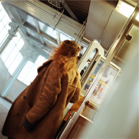 simsearch:695-03382580,k - Young woman walking through doors in subway station Fotografie stock - Premium Royalty-Free, Codice: 695-03382571