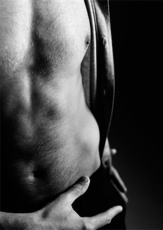 Man's bare torso, hand at waist, partial view, close up, black and white. Stock Photo - Premium Royalty-Free, Code: 695-03382654