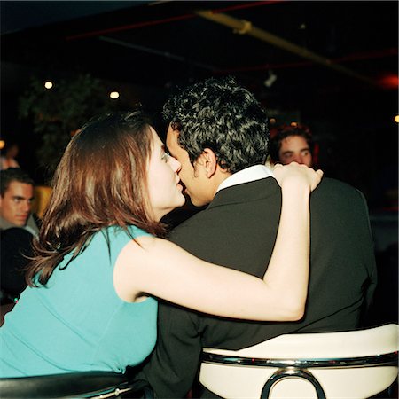 simsearch:632-01150072,k - Young woman kissing young man on cheek in bar, rear view Stock Photo - Premium Royalty-Free, Code: 695-03382877
