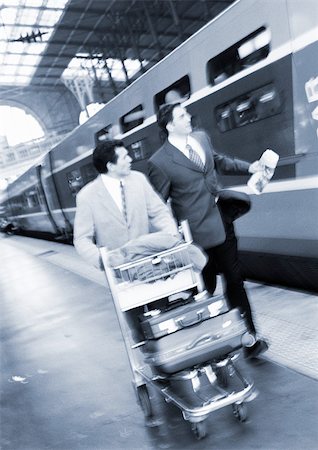 simsearch:695-03382908,k - Businessmen walking next to train on platform, b&w. Fotografie stock - Premium Royalty-Free, Codice: 695-03382899