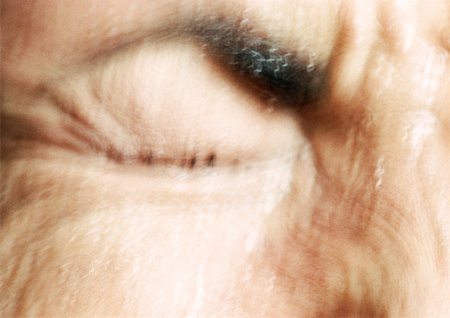 Partial view of woman's wrinkled face,  eye squeezed closed, blurred. Stock Photo - Premium Royalty-Free, Code: 695-03383051