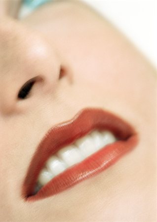 Woman wearing red lipstick, close up, partial view of face, blurred. Stock Photo - Premium Royalty-Free, Code: 695-03383238