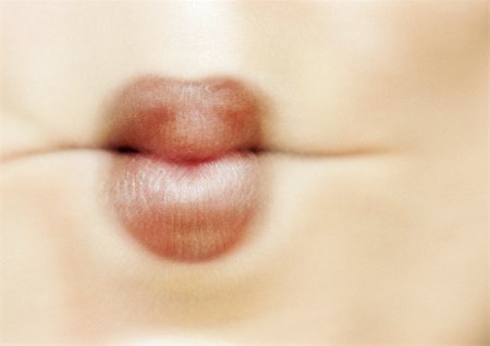 fish lips - Close up of woman's mouth sucking in cheeks, blurred Stock Photo - Premium Royalty-Free, Code: 695-03383289