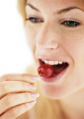 simsearch:696-03400445,k - Woman eating cherry, fingers in focus in foreground, close-up Stock Photo - Premium Royalty-Free, Code: 695-03383576
