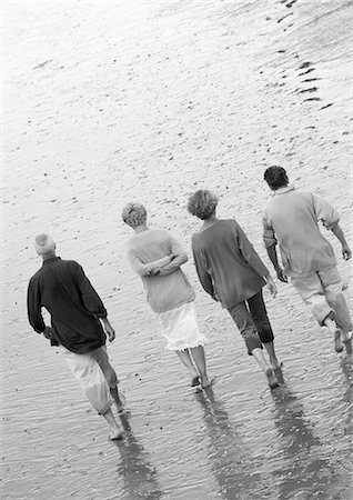 Four mature adults walking down the beach, view from rear, B&W Stock Photo - Premium Royalty-Free, Code: 695-03383700