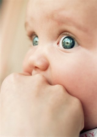 Baby's face and adult hand, close-up Stock Photo - Premium Royalty-Free, Code: 695-03383937