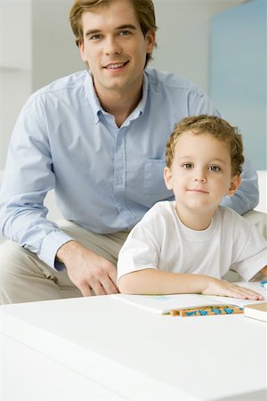simsearch:632-03083401,k - Father and son sitting together with book, both smiling at camera Foto de stock - Sin royalties Premium, Código: 695-03390091
