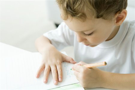 simsearch:695-05770157,k - Little boy sitting at table, drawing with colored pencil Foto de stock - Sin royalties Premium, Código: 695-03390114