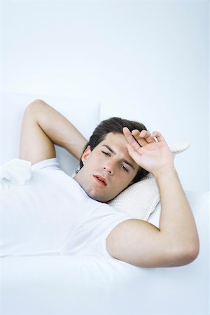 fragile - L'homme couché sur le canapé avec tissu sur sa poitrine, la main sur le front Photographie de stock - Premium Libres de Droits, Code: 695-03390125