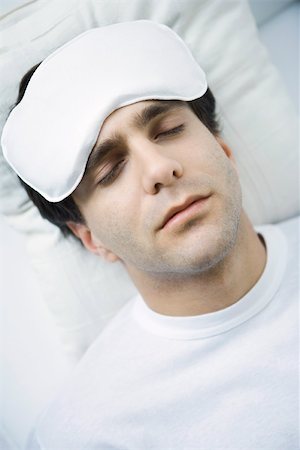 Man reclining with ice pack on his forehead, eyes closed Foto de stock - Royalty Free Premium, Número: 695-03390133