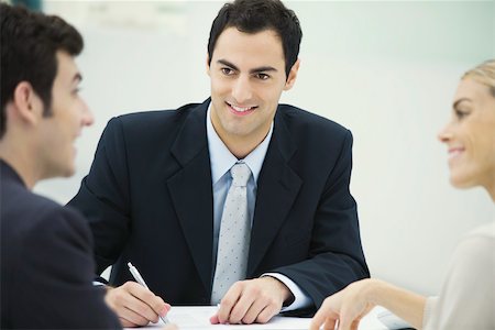 productivity - Business associates having discussion, smiling at each other, man taking notes Stock Photo - Premium Royalty-Free, Code: 695-03390181