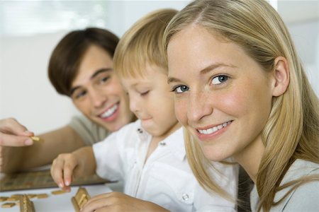 simsearch:632-02282914,k - Family playing board game, mother smiling at camera Stock Photo - Premium Royalty-Free, Code: 695-03390221