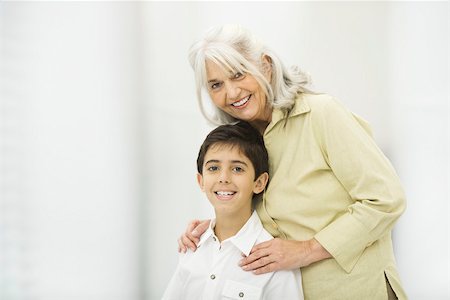 Grand-mère debout derrière le petit-fils, les deux souriant à la caméra, portrait Photographie de stock - Premium Libres de Droits, Code: 695-03390309