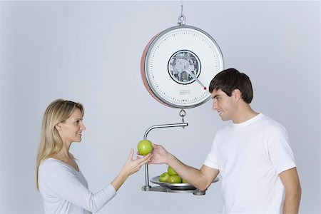 simsearch:649-03293611,k - Man weighing apples on scale, giving woman one apple Stock Photo - Premium Royalty-Free, Code: 695-03390301