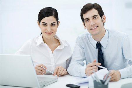 plain background - Collègues assis au comptoir, souriant à la caméra Photographie de stock - Premium Libres de Droits, Code: 695-03390365