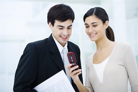 simsearch:632-03027019,k - Colleagues looking at cell phone together, smiling Stock Photo - Premium Royalty-Free, Code: 695-03390366