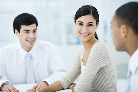 Young professional woman sitting with male colleagues, smiling at camera Foto de stock - Sin royalties Premium, Código: 695-03390371