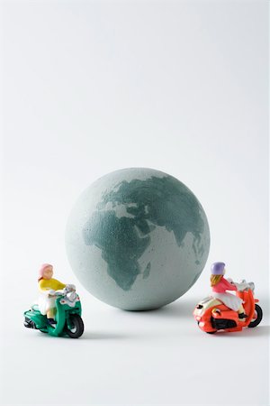Miniature mopeds circling globe Stock Photo - Premium Royalty-Free, Code: 695-03390422
