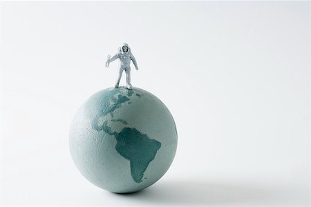 Miniature astronaut standing on top of globe Stock Photo - Premium Royalty-Free, Code: 695-03390449
