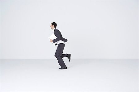 Businessman running with document, blurred motion Stock Photo - Premium Royalty-Free, Code: 695-03390531
