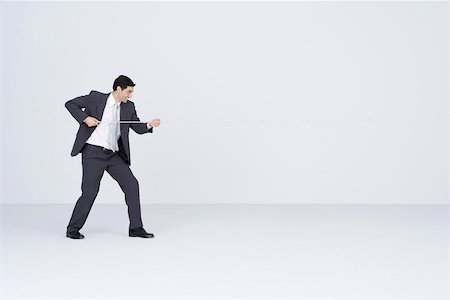 Side View Of A Man Pulling Rope On White Background Royalty Free