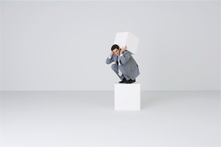 Businessman lifting block on back Stock Photo - Premium Royalty-Free, Code: 695-03390546