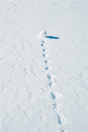 Snowball leaving trail as it rolls through snow Stock Photo - Premium Royalty-Free, Code: 695-03390601
